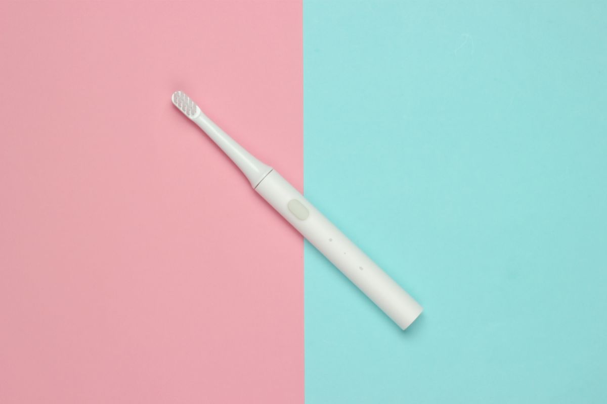 Electric toothbrush on the pink and blue background